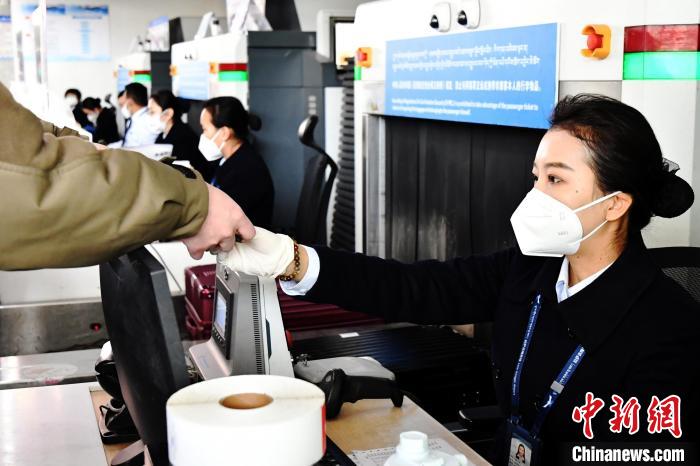 圖為機(jī)場(chǎng)工作人員為旅客辦理行李托運(yùn)?！≈芎?攝