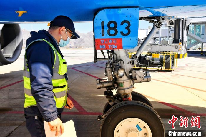 圖為機(jī)場(chǎng)工作人員進(jìn)行相關(guān)檢查?！≈芎?攝