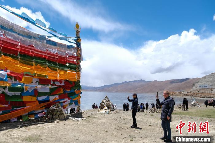 進(jìn)藏參訪嘉賓在羊湖畔拍攝經(jīng)幡?！〗w波 攝