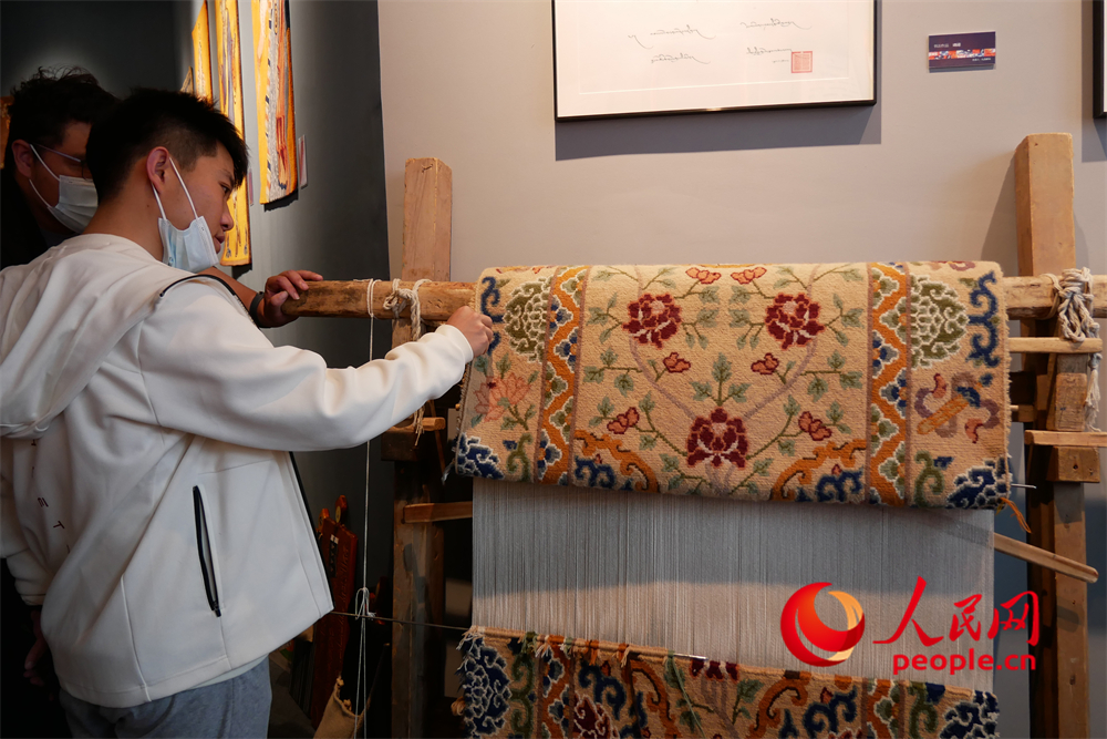 觀眾正在觀賞展出的藏毯。人民網(wǎng) 韋衍行攝