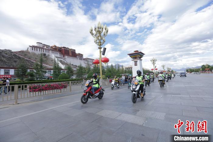 圖為比賽選手途經(jīng)布達拉宮?！∮文恋厍蚬﹫D