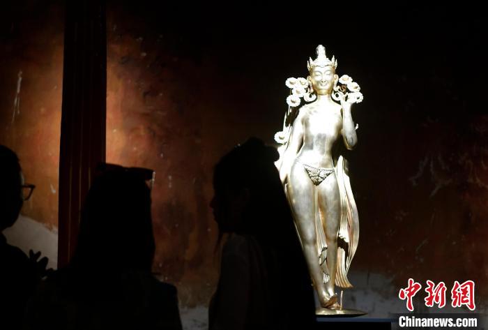 圖為觀眾正在欣賞展覽中的雕塑作品《八萬四千年》?！±盍?攝