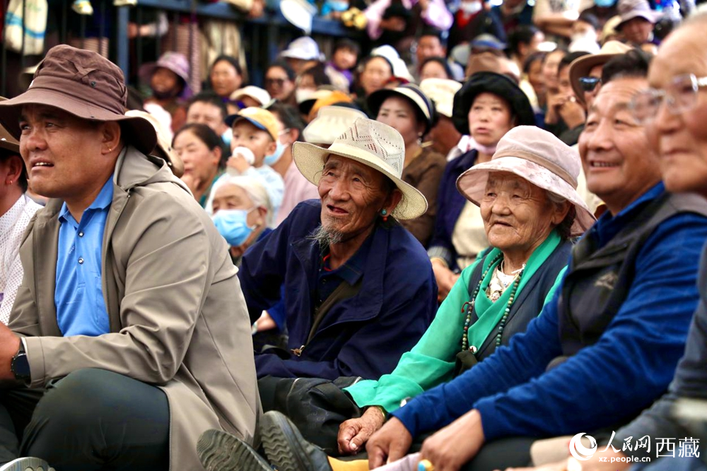 當(dāng)?shù)厝罕姾陀慰陀^看藏戲演出。