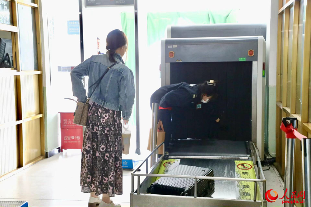 車站工作人員幫旅客提取行李。人民網(wǎng)記者 次仁羅布攝