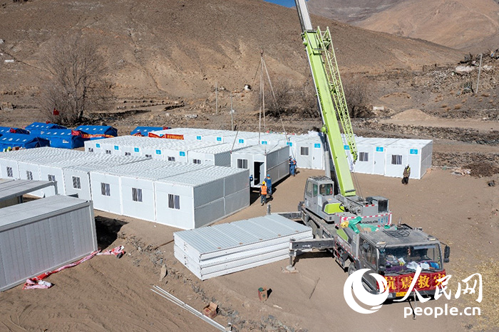 1月9日，在日喀則市定日縣長所鄉(xiāng)古榮村安置點，救援人員和施工人員合力抓緊搭建移動板房，確保受災(zāi)群眾溫暖過冬。人民網(wǎng)記者 翁奇羽攝