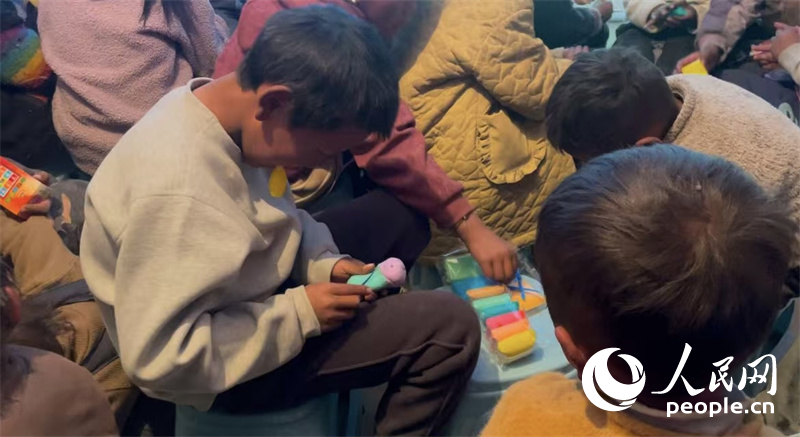 措果鄉(xiāng)塘仁村的孩子們正在用橡皮泥制作自己的情緒“小怪獸”。人民網(wǎng)記者 郝潔攝