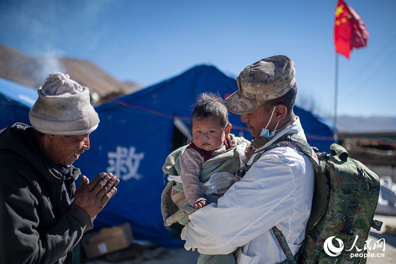 1月9日，在定日縣長所鄉(xiāng)古榮村安置點，受災群眾感謝西藏軍區(qū)陸軍某部隊衛(wèi)生員的醫(yī)療救治。人民網記者 翁奇羽攝