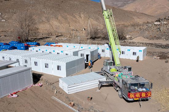 2025年1月9日，在定日縣長所鄉(xiāng)古榮村安置點(diǎn)，救援人員和施工人員合力抓緊搭建移動板房，確保受災(zāi)群眾溫暖過冬。人民網(wǎng)記者 翁奇羽攝