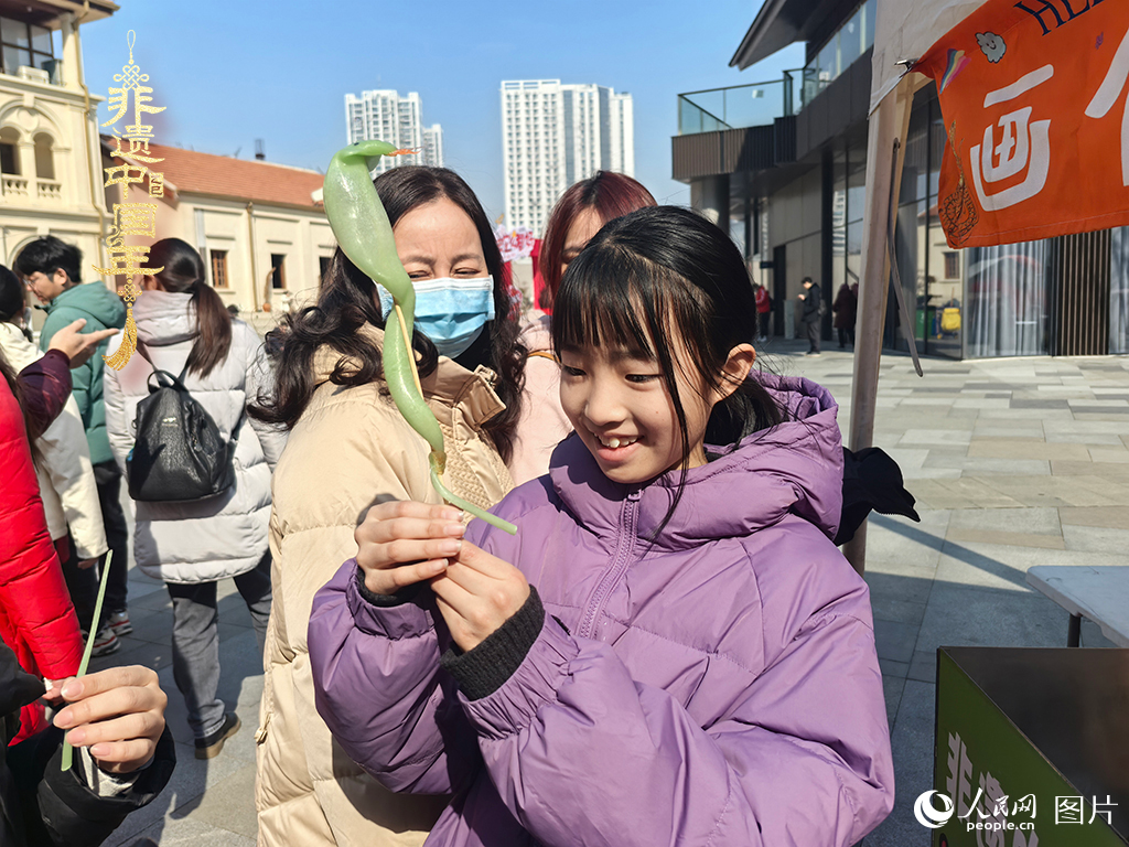 2025年1月29日，湖北武漢的新春廟會上，小朋友拿著吹制好的糖人，十分開心。人民網(wǎng)記者 張沛攝