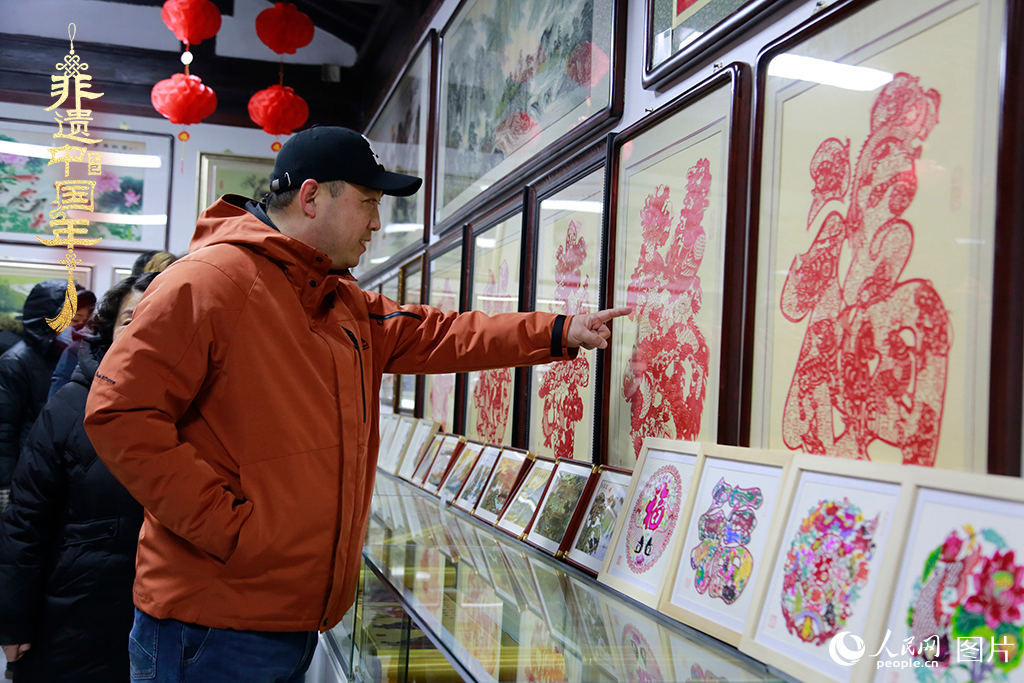 2025年1月23日，游客在天津楊柳青古鎮(zhèn)欣賞傳統(tǒng)剪紙作品，感受指尖上的古老藝術(shù)。人民網(wǎng)記者 崔新耀攝